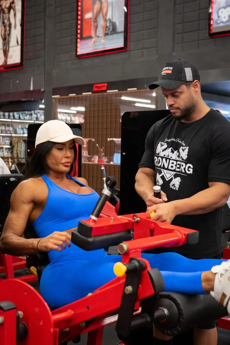 Hugo Tisk orientando uma aluna durante exercício na academia